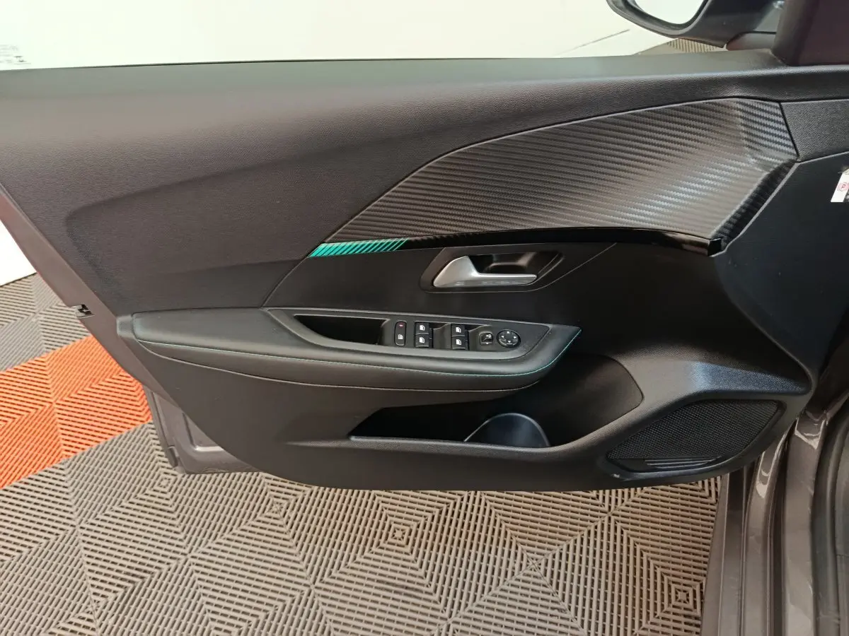 Vue latérale du panneau de porte avant gauche de Peugeot 208 2020 avec garniture noire et insert effet carbone.