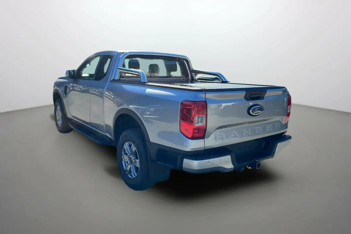 Ford Ranger gris iconic vu en 3/4 arrière droit avec arceaux inox et rideau de benne fermé.
