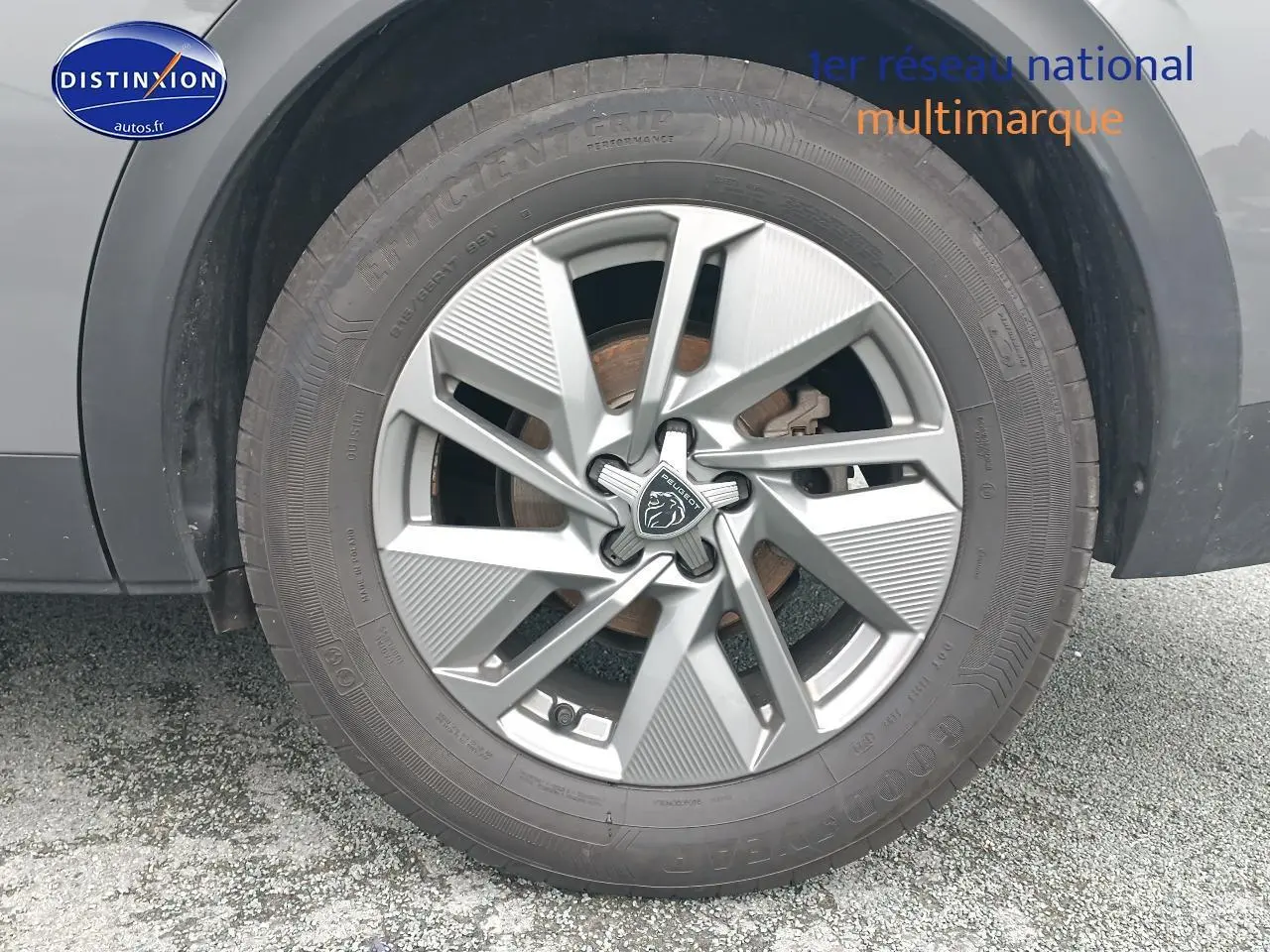 Gros plan sur la jante alu grise avec logo Peugeot, montée sur un pneu Goodyear, partie latérale du Peugeot 408 gris Sellenium.