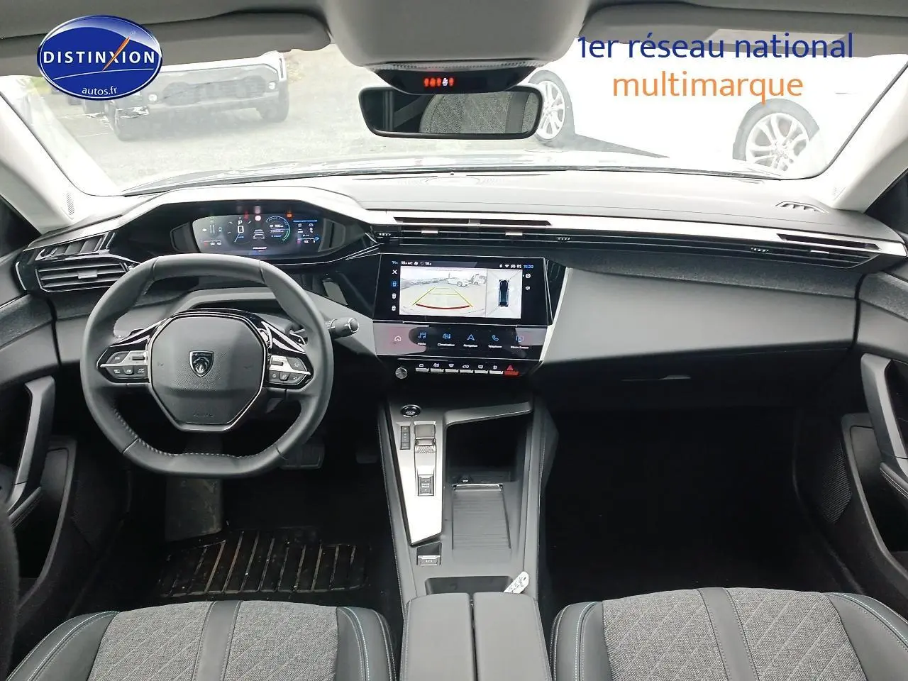Vue intérieure avant du Peugeot 408 Hybrid 145 allure 2024, tableau de bord moderne avec écran tactile et volant multifonction.