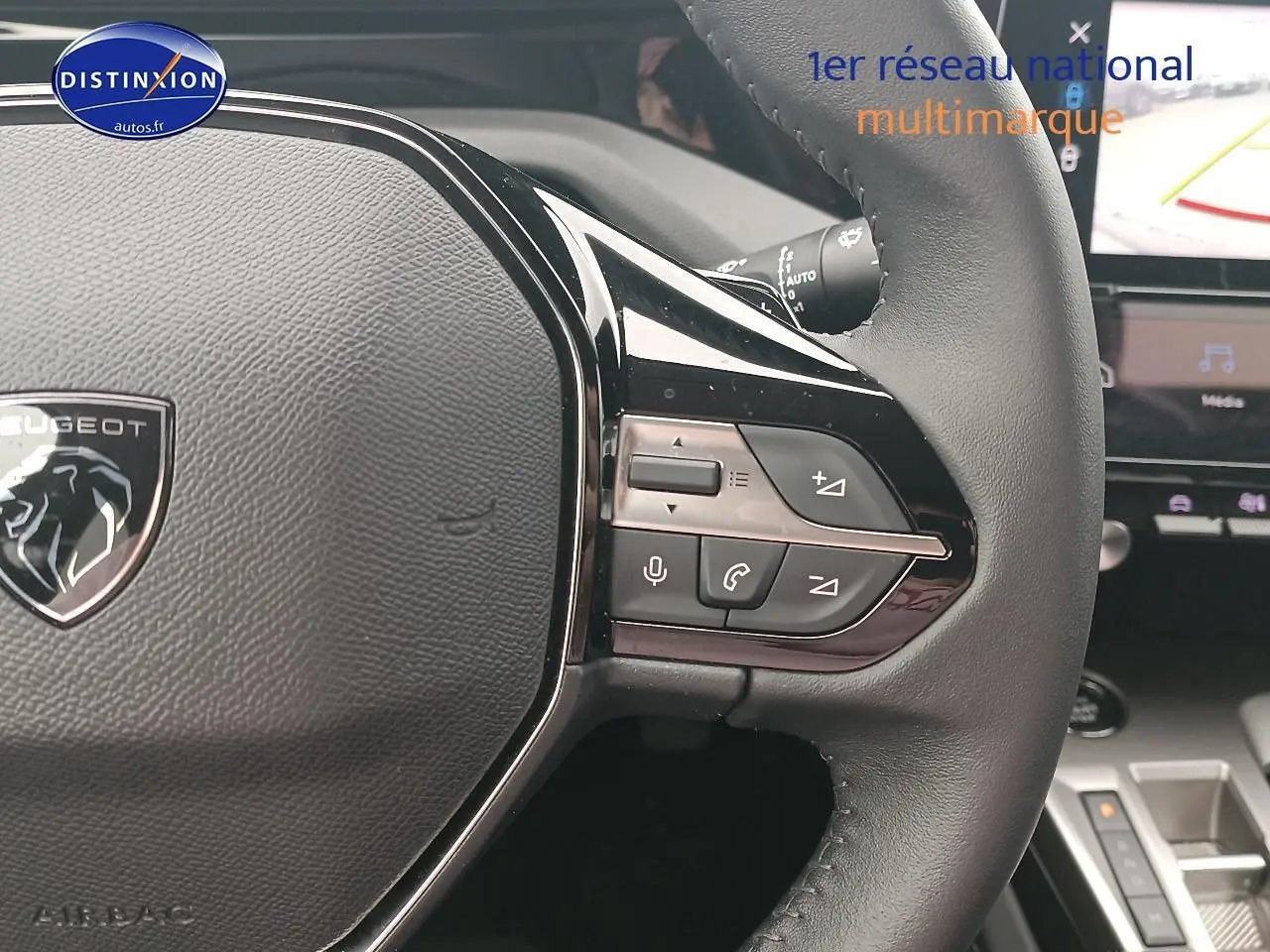 Gros plan sur le volant cuir multifonction de la Peugeot 408 Hybrid 145 allure 2024 avec commandes vocales et audio intégrées.