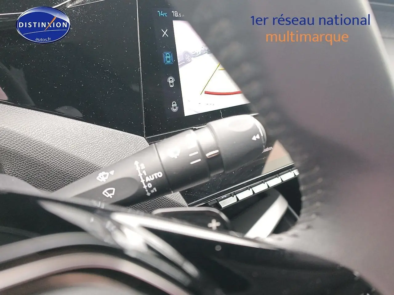 Gros plan sur la commande d’essuie-glace et l’écran tactile intérieur de la Peugeot 408 Hybrid 145 allure gris sélénite.