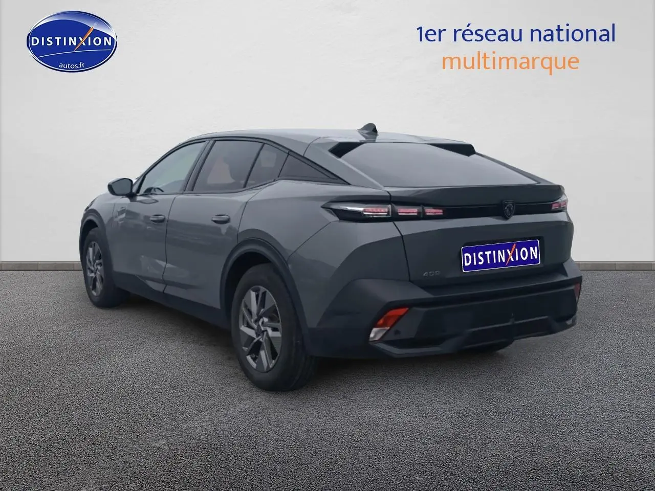 Vue 3/4 arrière droite d'une Peugeot 408 Hybrid 145 allure gris sélénite avec feux arrière LED et jantes alu.