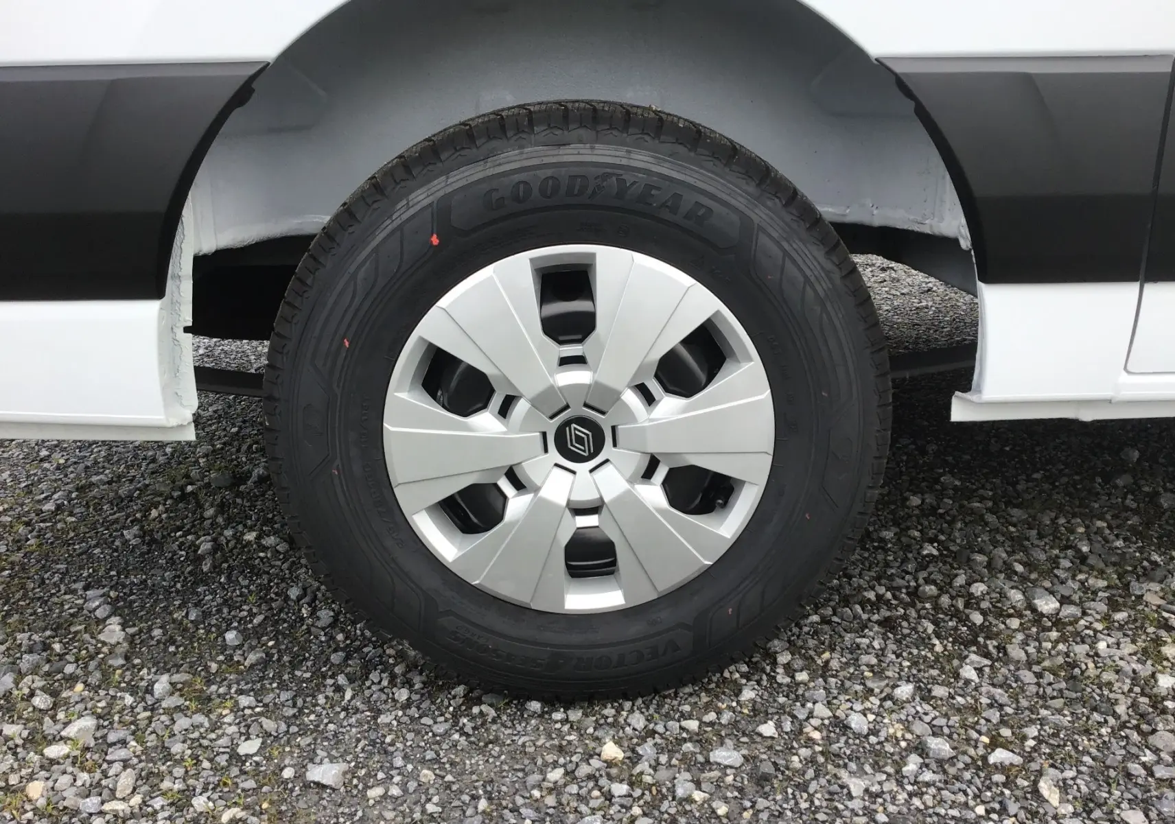 Gros plan sur la roue avant gauche blanche du Renault Master L2H2 2026 avec jante argentée et pneu Goodyear tous temps.