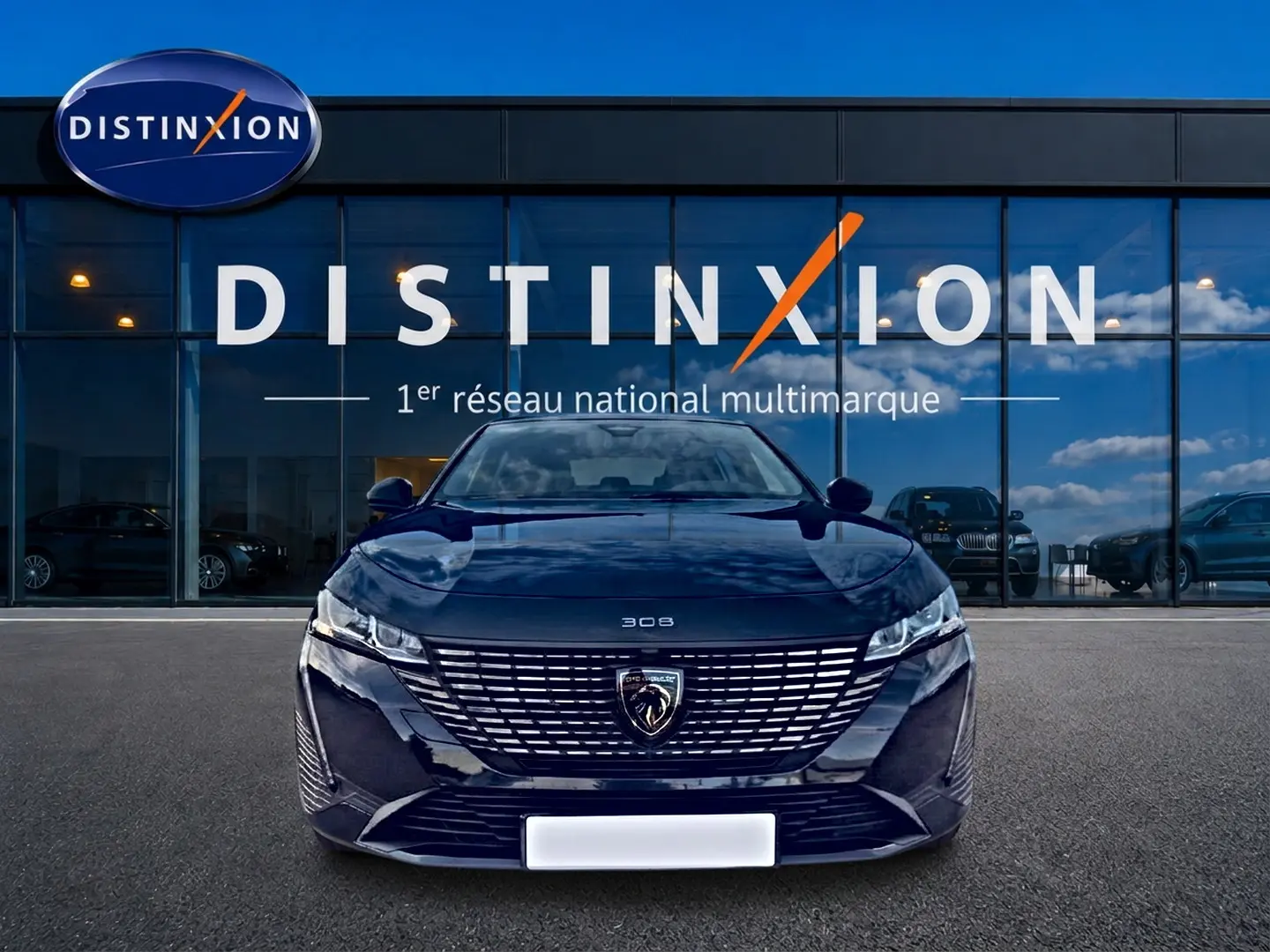 Vue frontale d'une Peugeot 308 noire 2025 avec calandre distinctive et logo lion au centre, devant une vitrine Distinxion.