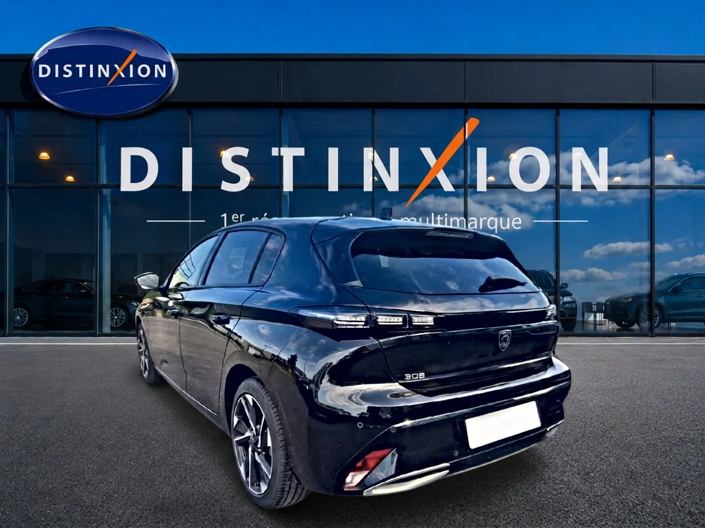 Peugeot 308 noire vue 3/4 arrière droite, avec feux arrière LED et jantes alliage devant une vitrine Distinxion.