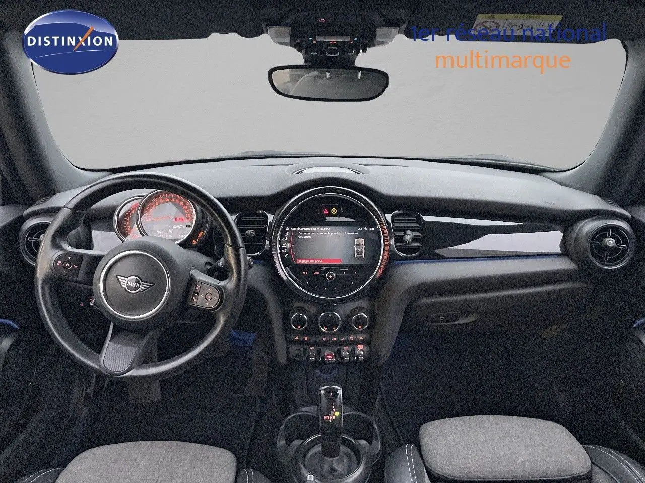 Intérieur de MINI Cabriolet F57 2023, vue frontale du tableau de bord avec volant cuir noir et écran central rond.
