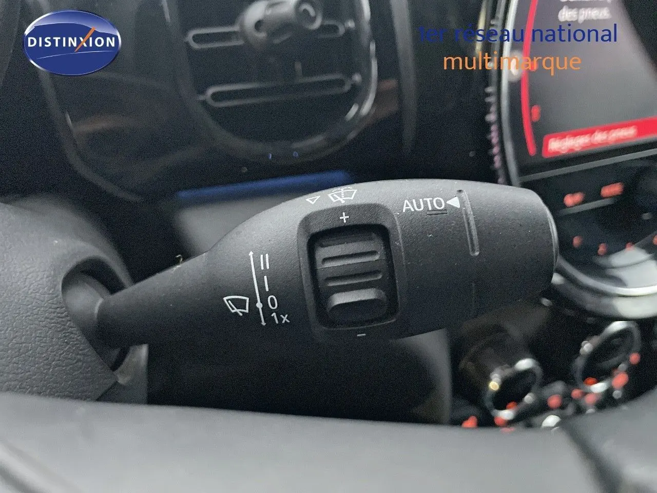 Gros plan sur la commande d'essuie-glace à gauche du volant dans l'habitacle d'une MINI Cabriolet rouge chili 2023.