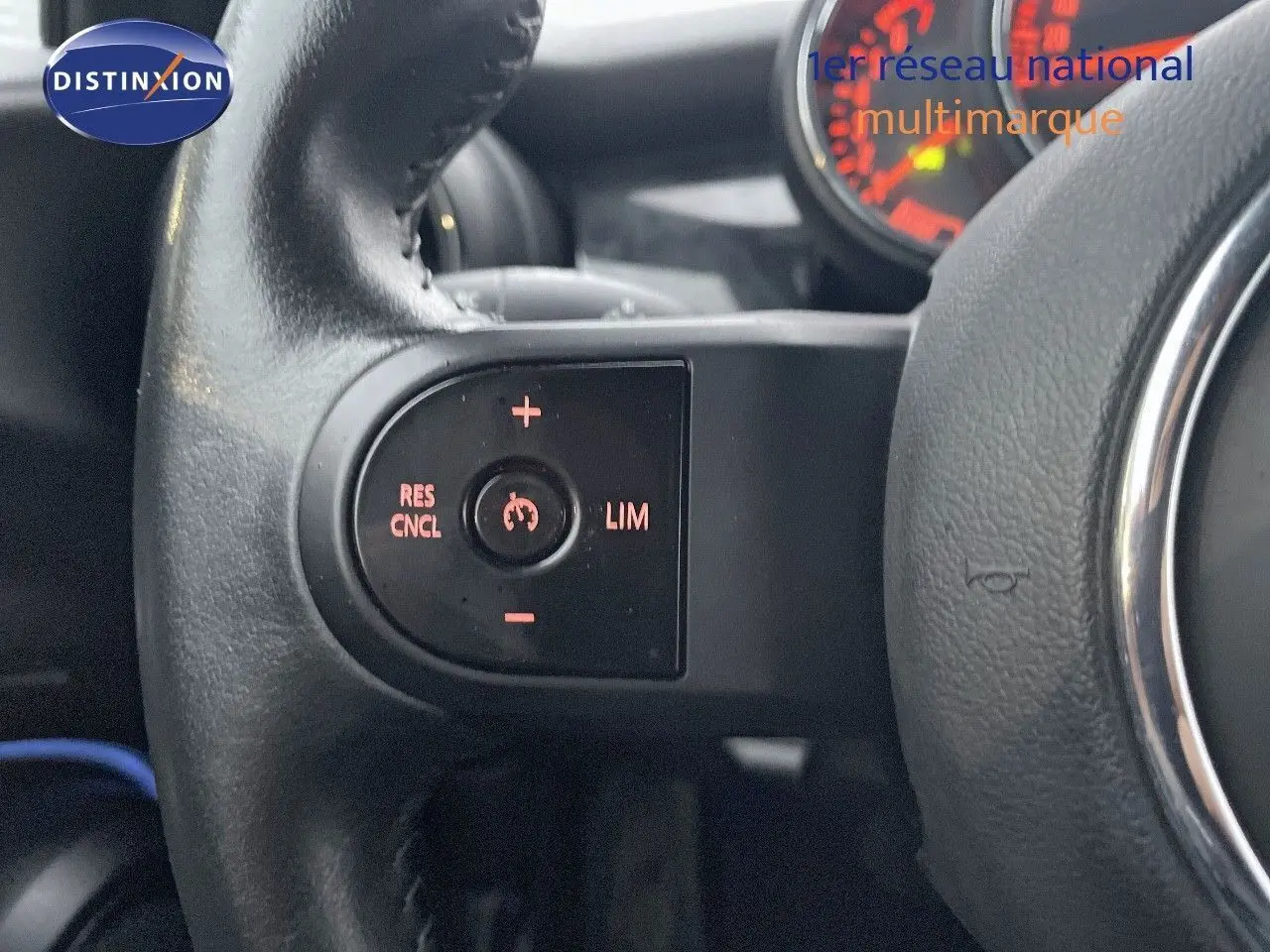 Gros plan sur les commandes de régulateur de vitesse au volant d'une MINI Cabriolet F57 rouge chili de 2023.