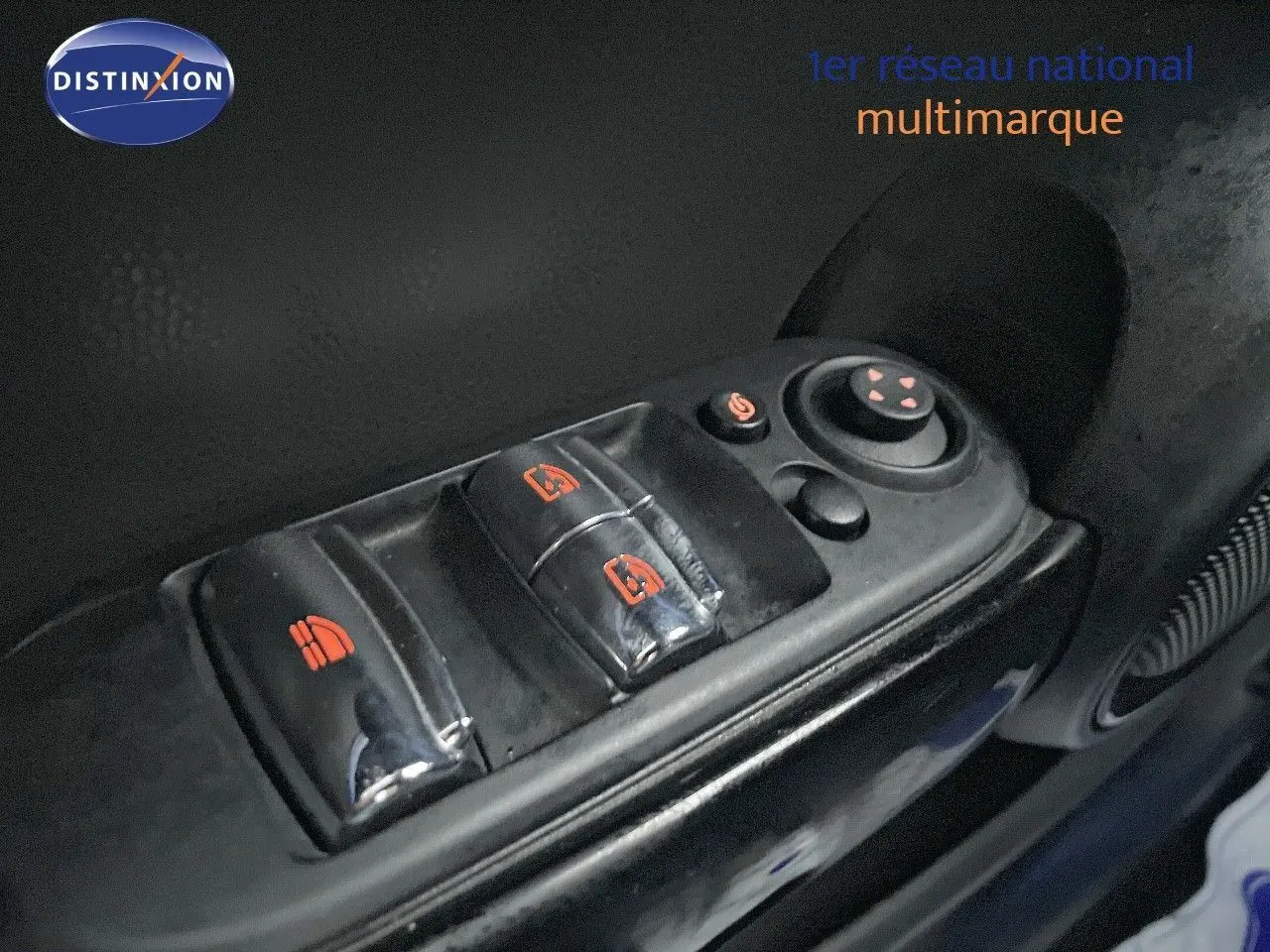 Gros plan sur les commandes de lève-vitres et réglage des rétroviseurs côté conducteur d'une MINI Cabriolet rouge chili 2023.