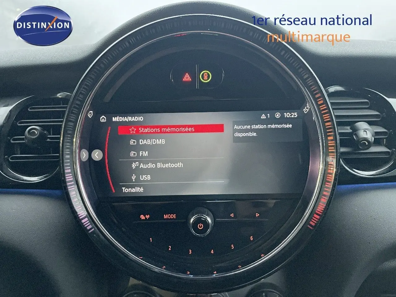 Écran central circulaire du tableau de bord de la MINI Cabriolet rouge chili 2023 affichant le menu média et radio.