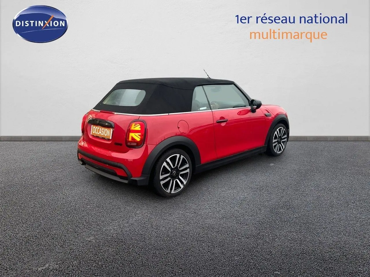 MINI Cabriolet F57 rouge chili vue 3/4 arrière côté droit avec toit souple noir et feux arrière à motif Union Jack.