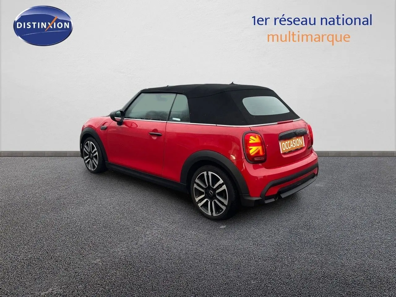 Vue 3/4 arrière droite d'une MINI Cabriolet F57 rouge chili avec capote noire et feux arrière à motif Union Jack.