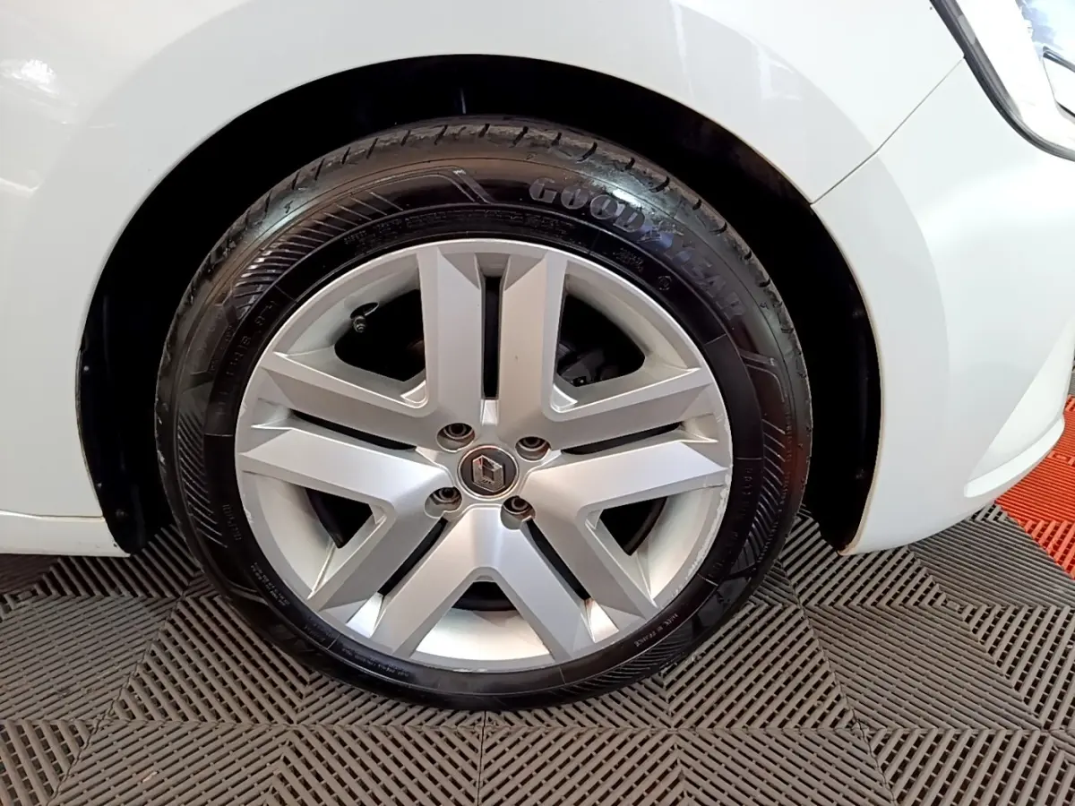 Gros plan sur la roue avant droite d'une Renault Clio blanche avec jante alliage et pneu Goodyear.