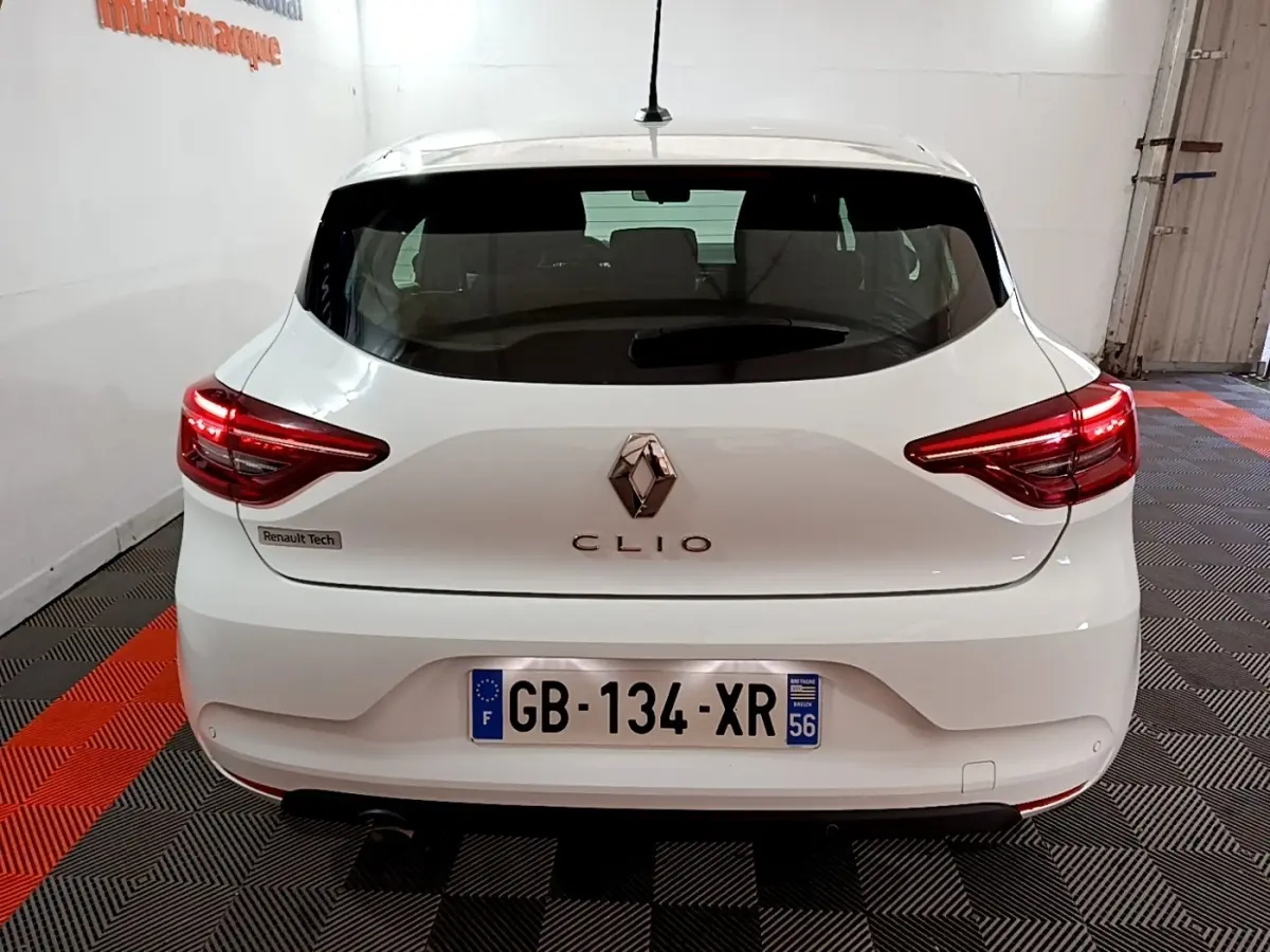 Vue arrière d'une Renault Clio Business blanche de 2021 avec feux LED allumés et logo central visible.