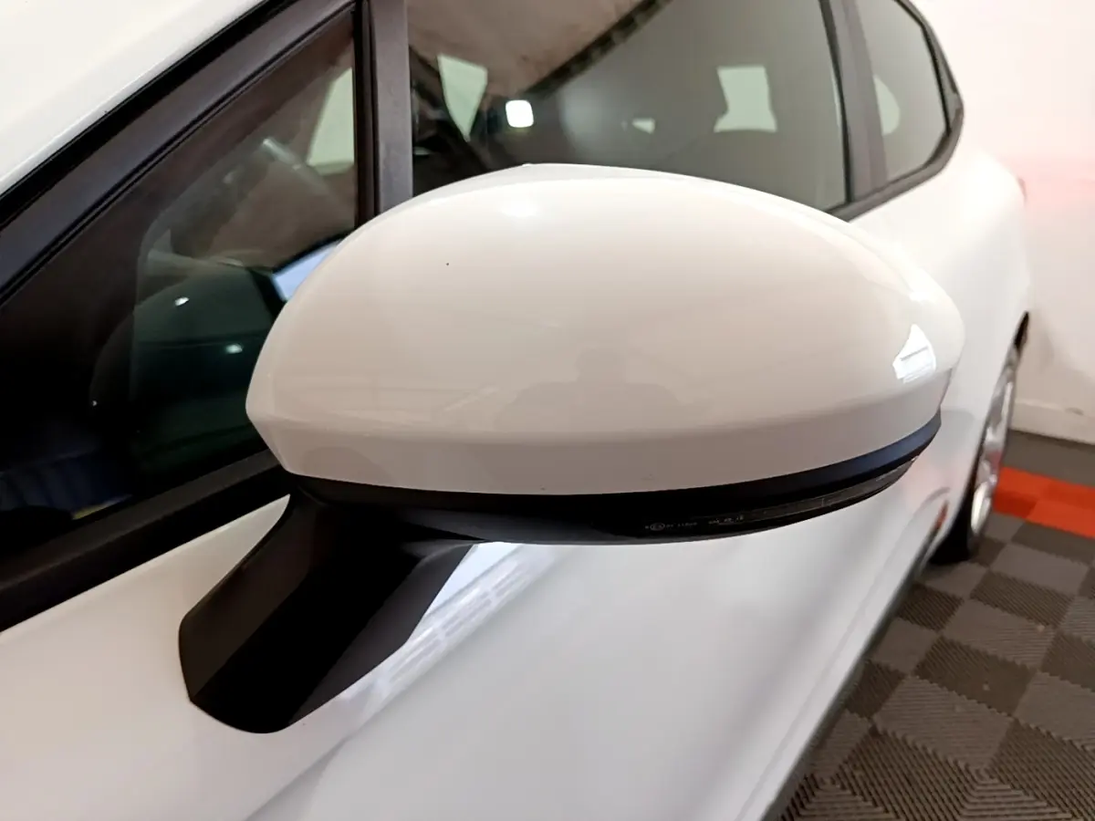 Rétroviseur blanc côté gauche en gros plan sur Renault Clio Business 2021, carrosserie blanche visible en arrière-plan.