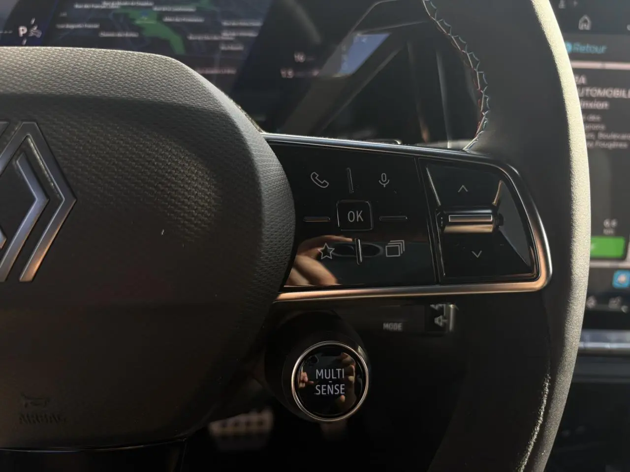 Gros plan sur le volant Alcantara avec surpiqûres tricolores et commandes multifonctions du Renault Rafale E-Tech Gris Schiste.