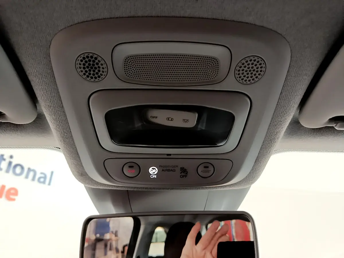 Vue intérieure du plafonnier gris clair avec boutons SOS et assistance de la FIAT 500 électrique blanche 2022.
