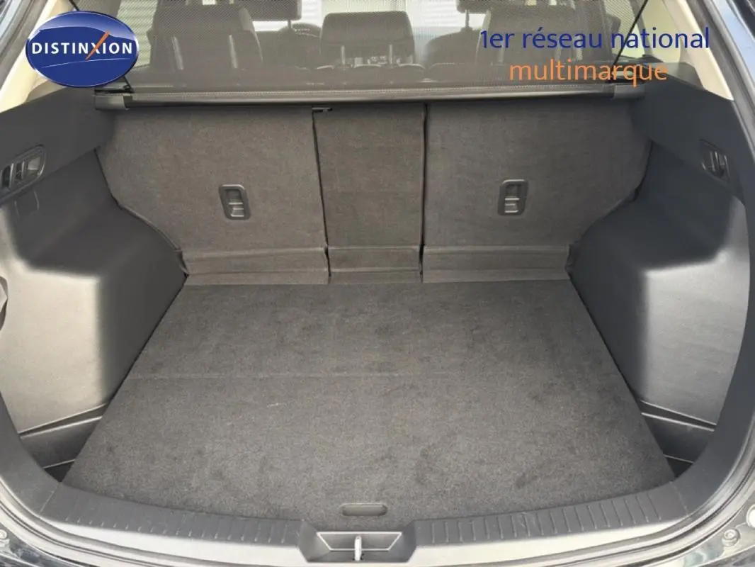 Coffre ouvert d'un Mazda CX-5 noir 2017, montrant un espace de chargement propre et bien agencé.