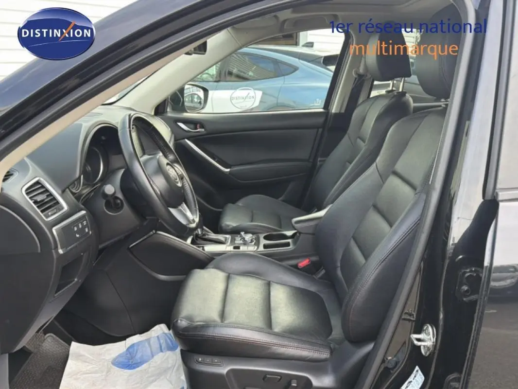 Intérieur noir du Mazda CX-5 2017, vue côté conducteur avec sièges cuir et console centrale visible.