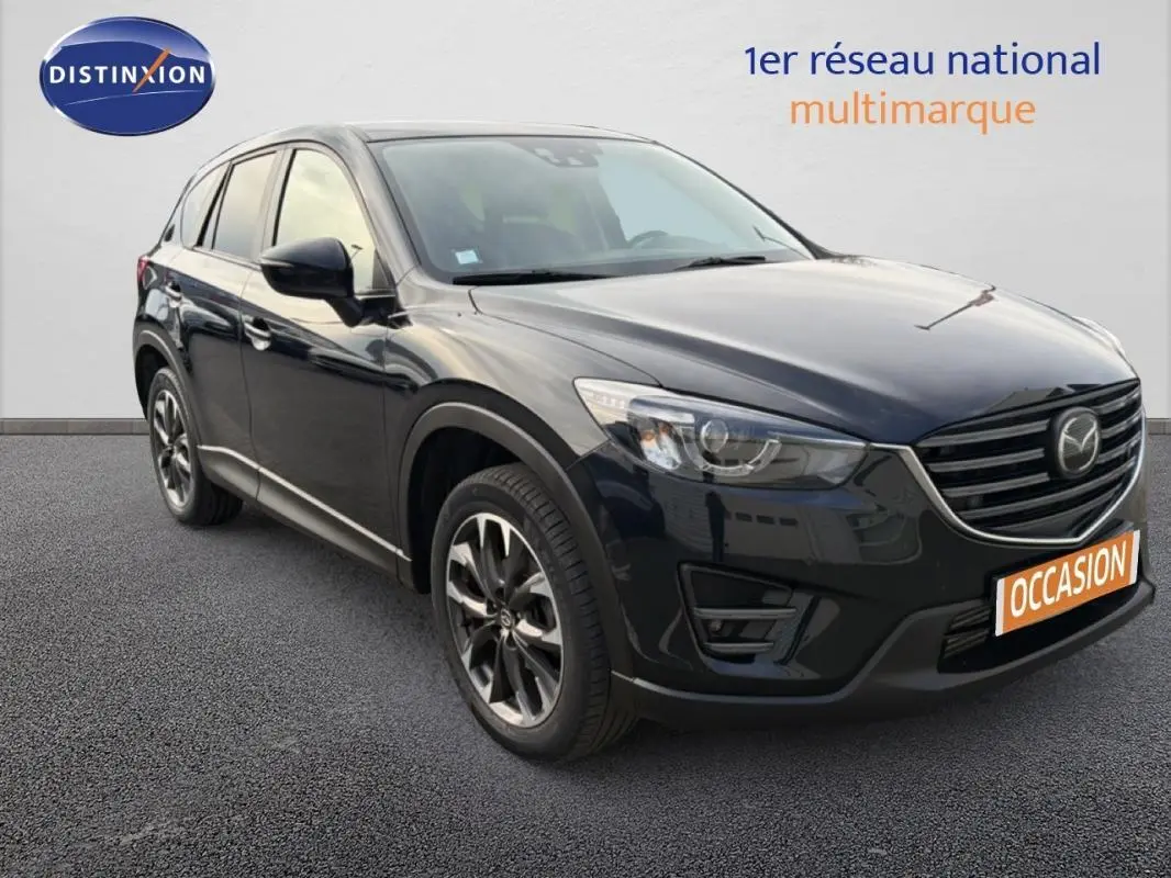 Vue 3/4 avant d'un Mazda CX-5 noir 2017 avec jantes alliage 19 pouces et calandre distinctive au logo Mazda.