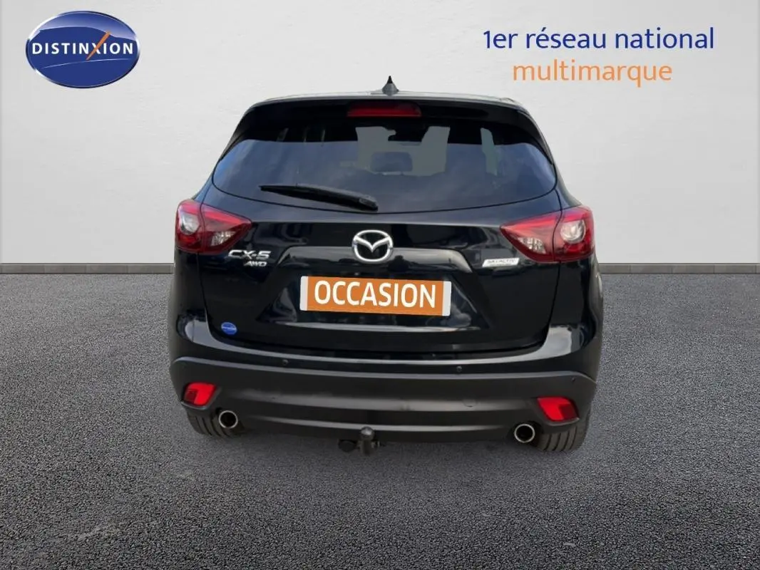 Vue arrière d'un Mazda CX-5 noir 2017 avec attelage et feux arrière LED sur fond neutre.