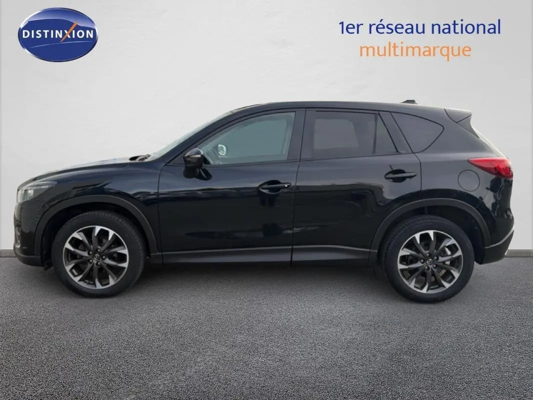 Vue latérale droite d'un Mazda CX-5 noir de 2017 avec jantes alliage et rétroviseurs électriques rabattables.