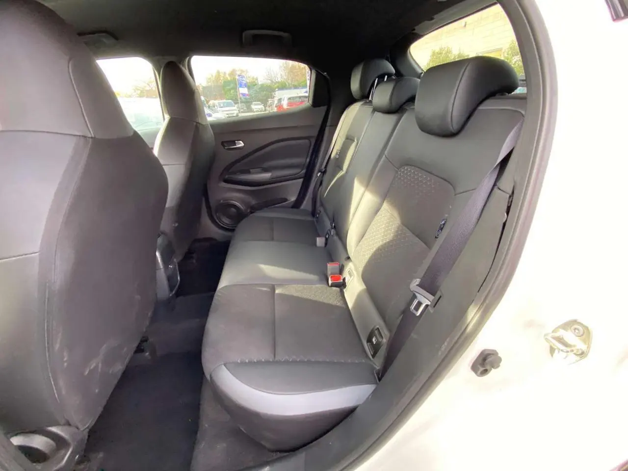 Vue intérieure côté droit sur les sièges arrière noirs du Nissan Juke blanc perle 2024, finition N-Connecta.