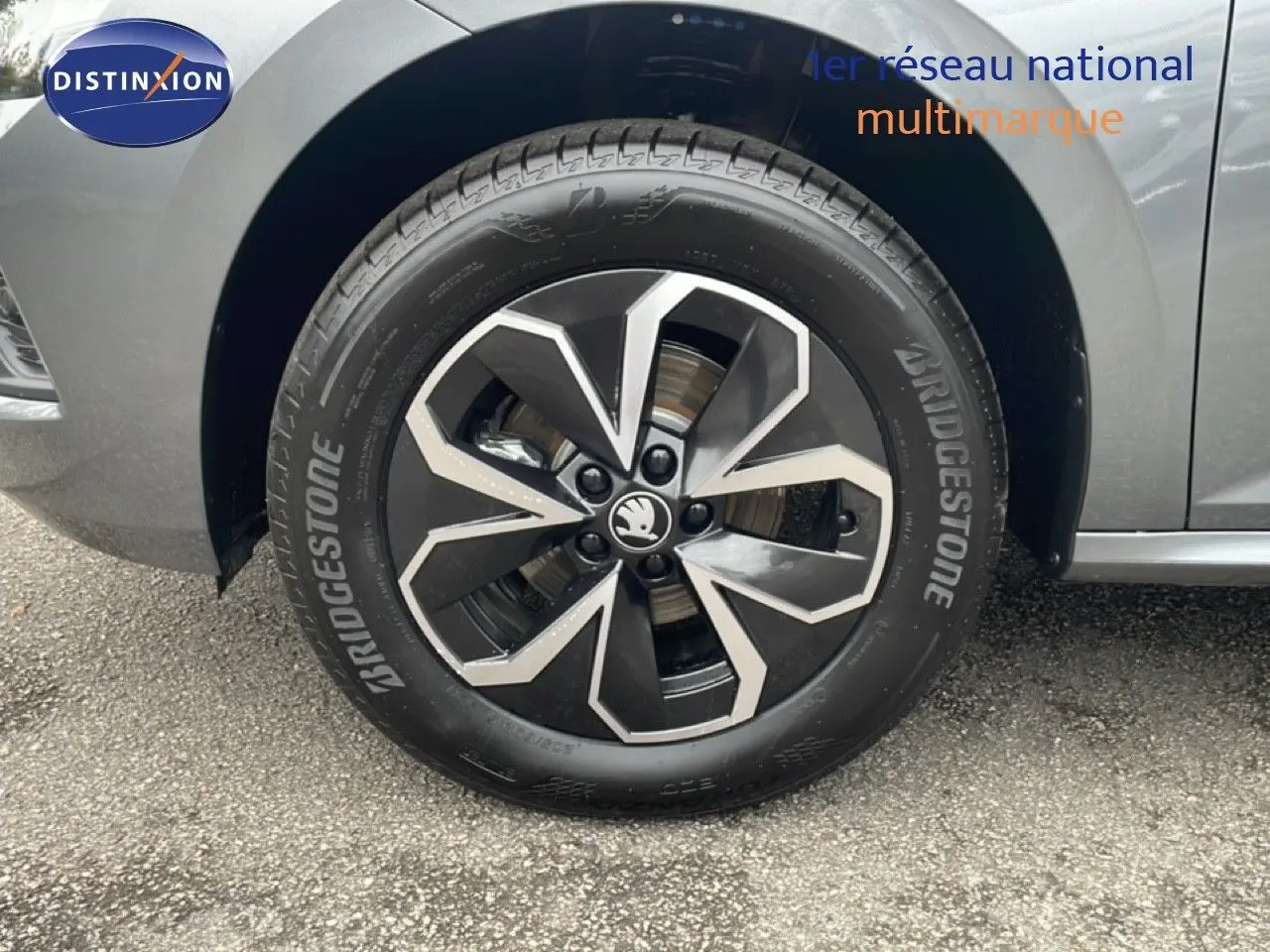 Gros plan sur la roue avant gauche du Skoda Kamiq gris graphite métal avec jante alliage noire et argentée.