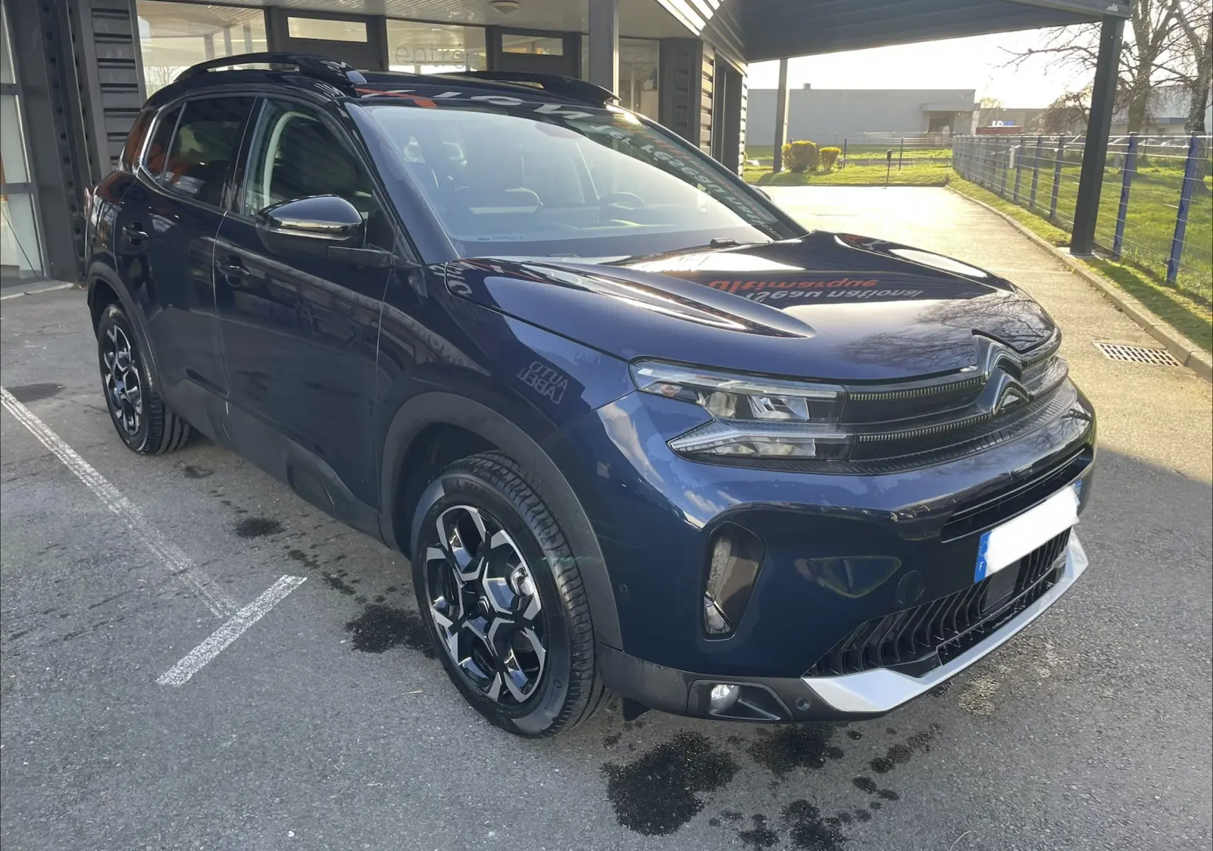 Citroën C5 Aircross hybride bleu Eclipse vue 3/4 avant droit, jantes alliage 18'' biton et barres de toit visibles.