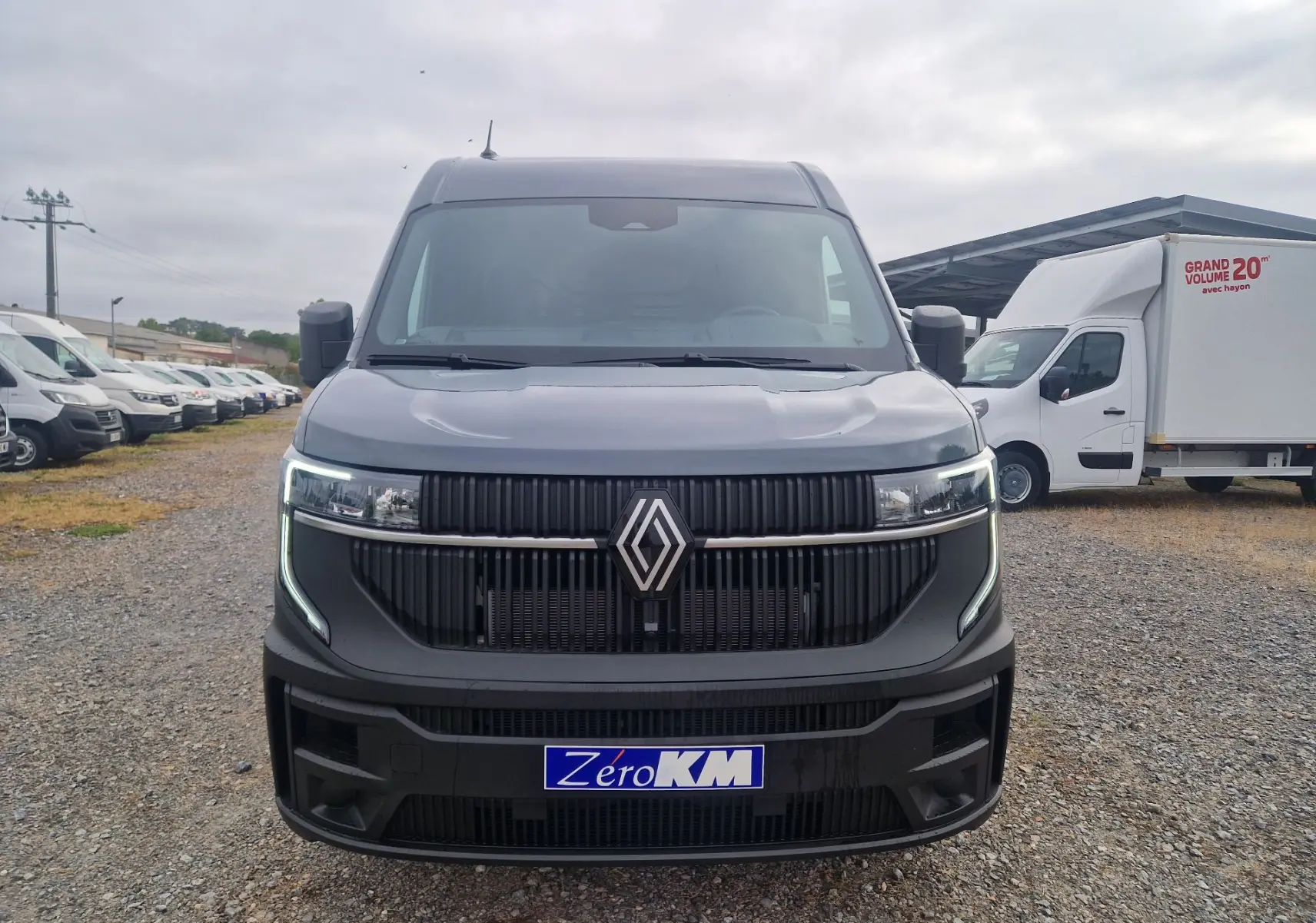 Vue avant d’un Renault Master gris urbain 2026 avec calandre noire et feux LED en forme de C allumés.