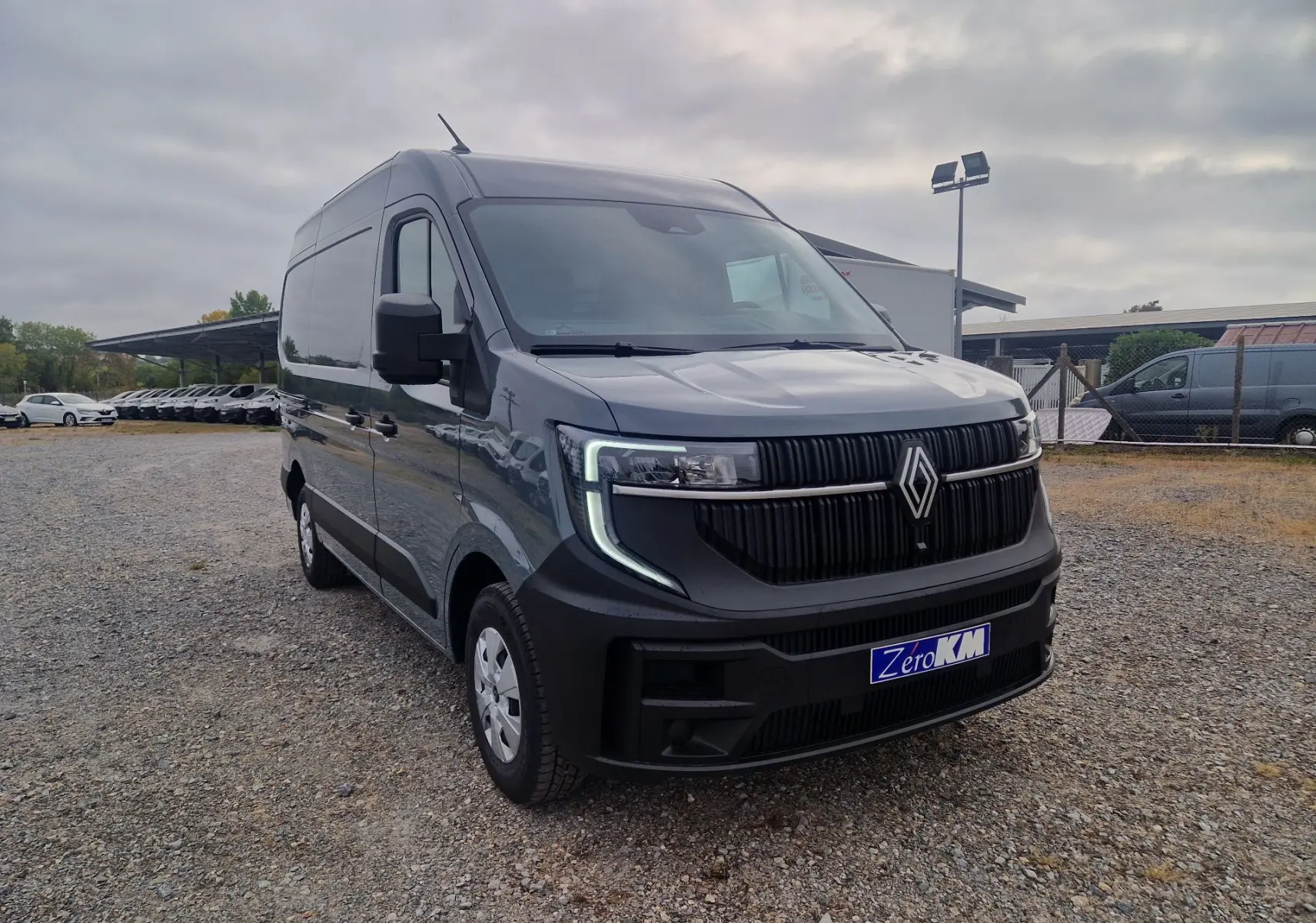 Renault Master gris urbain en 3/4 avant droit, avec calandre noire verticale et feux LED en forme de C.