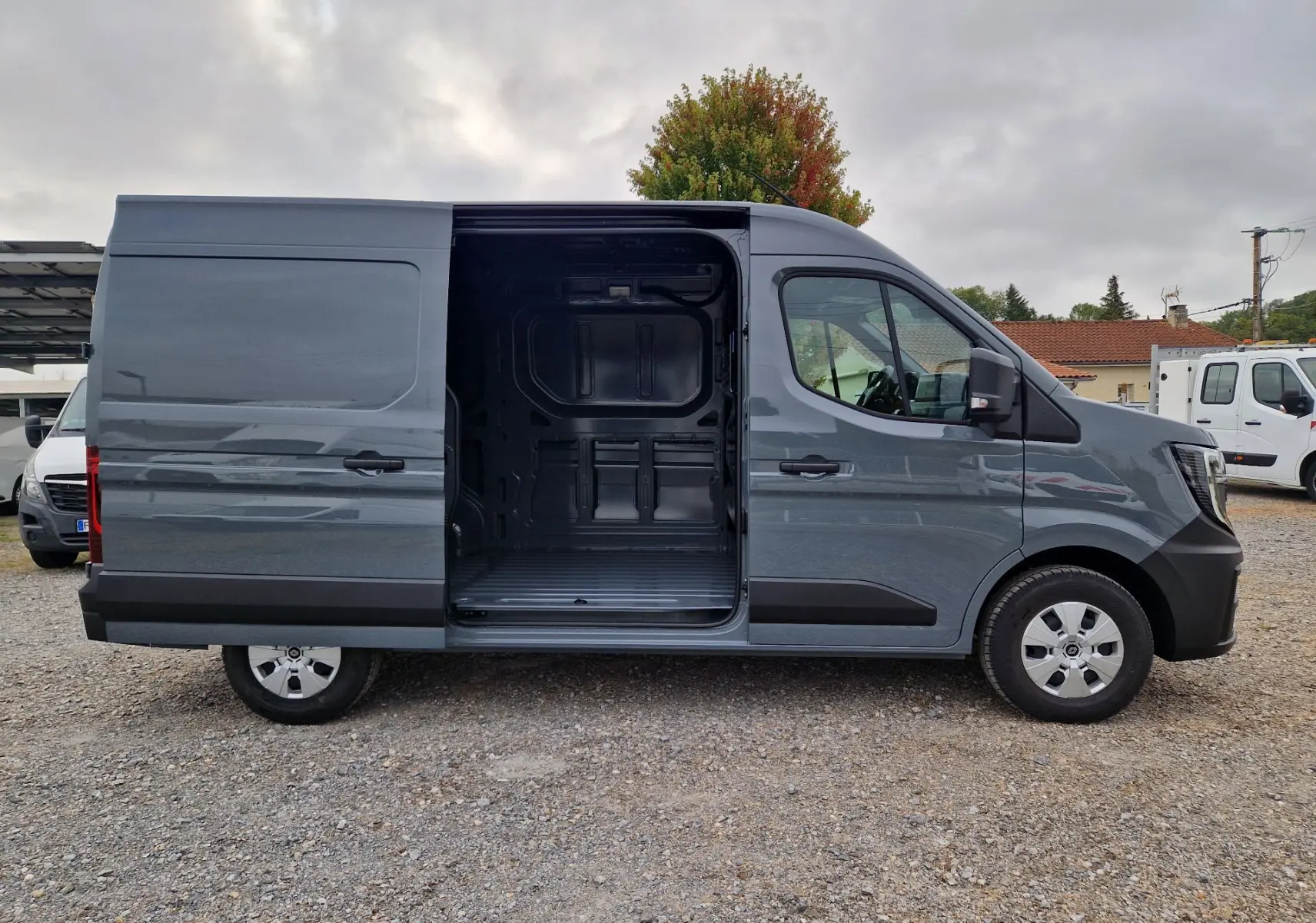 Renault Master gris urbain en vue de profil côté droit, porte latérale coulissante ouverte montrant l’espace de chargement.