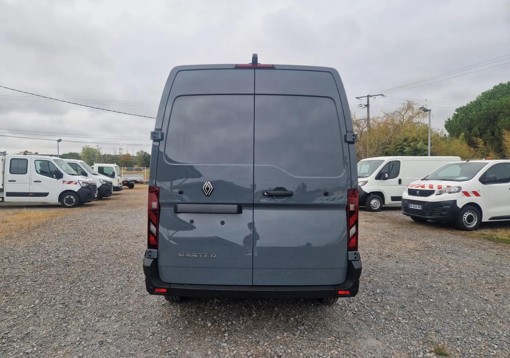 Vue arrière d’un Renault Master gris urbain 2026, avec portes battantes fermées et feux arrière verticaux.