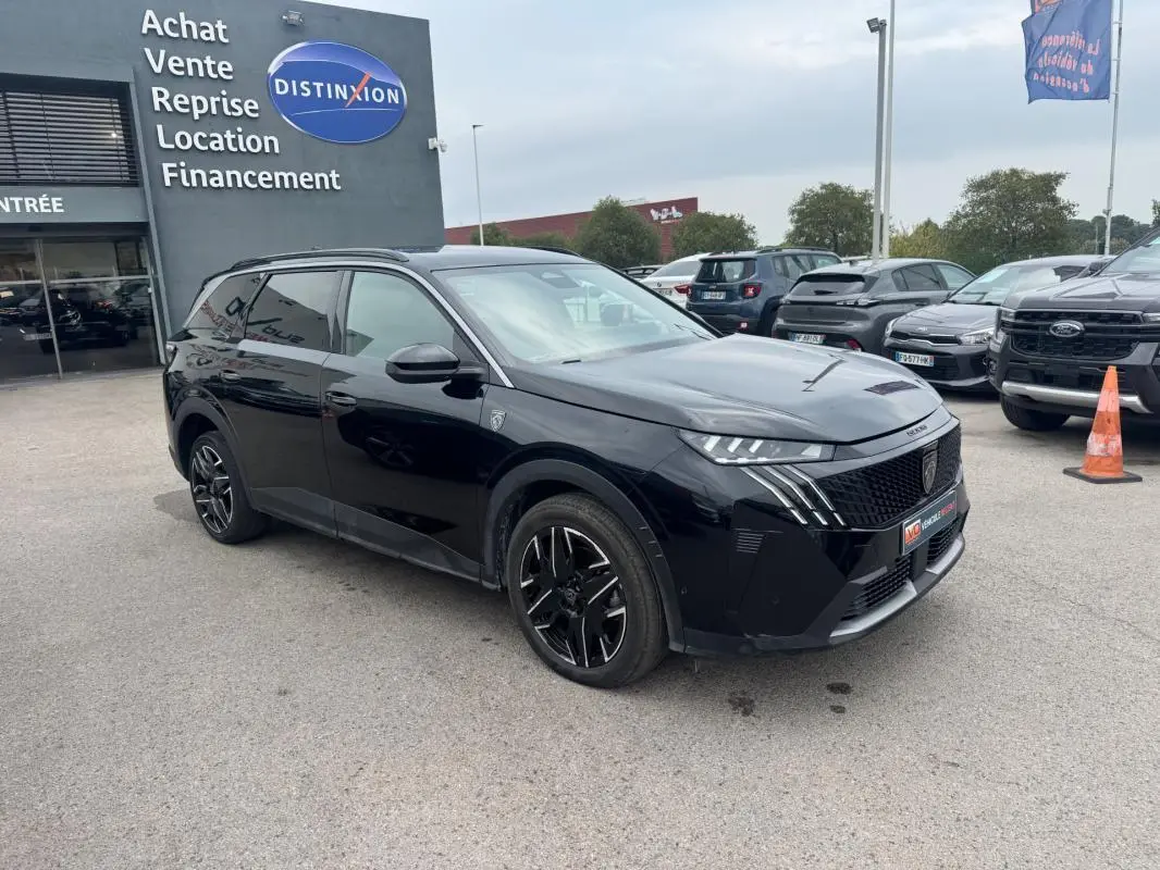 Peugeot 5008 Hybrid noir en 3/4 avant droit, avec jantes alliage noires et barres de toit visibles.