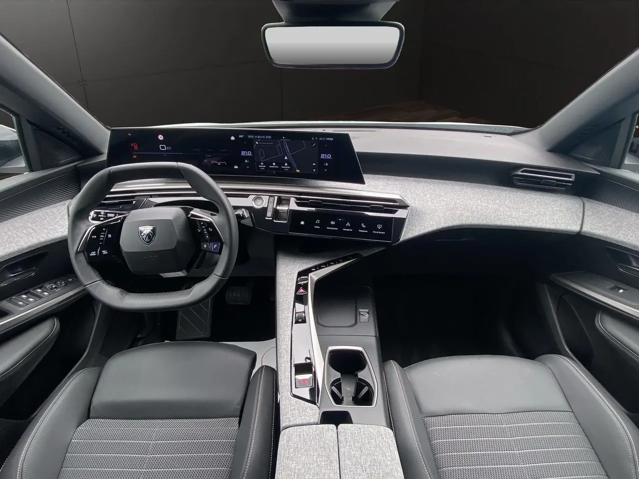 Intérieur noir et gris du Peugeot 3008 2024, vue de face sur le tableau de bord et le volant compact.