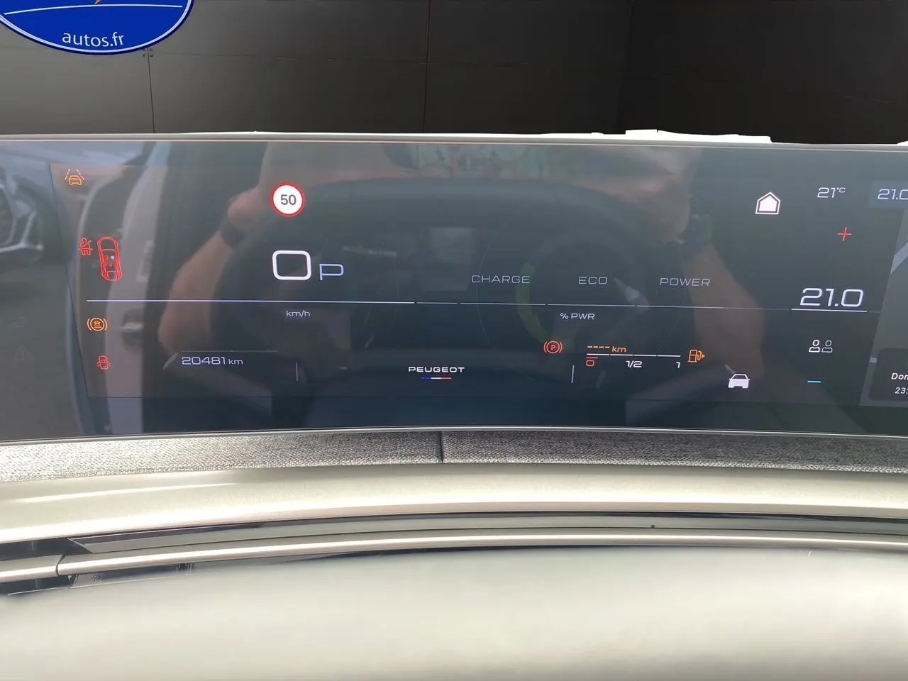Affichage numérique du tableau de bord du Peugeot 3008 hybride blanc, montrant la vitesse, autonomie et température intérieure.