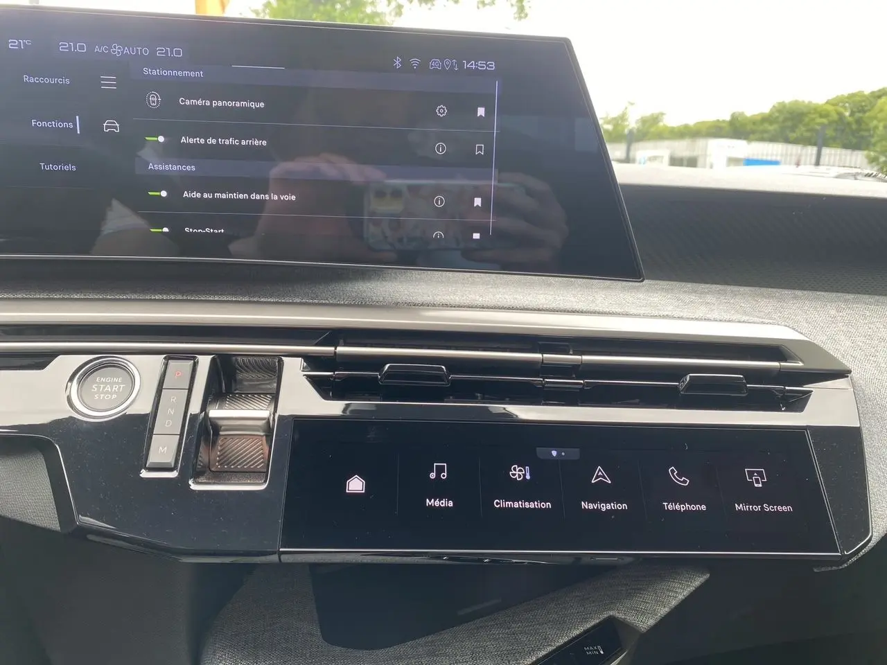 Tableau de bord du Peugeot 3008 hybride 2024 avec écran tactile panoramique et commandes modernes en vue frontale rapprochée.