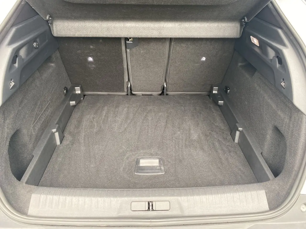 Coffre spacieux du Peugeot 3008 blanc Okenite vu de l'arrière, avec intérieur noir et plancher plat.