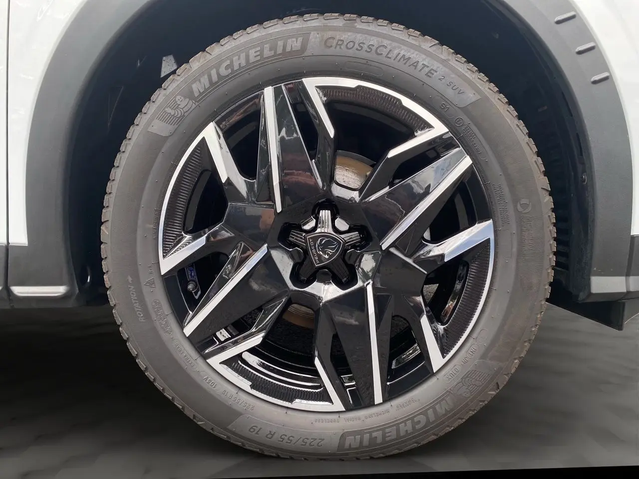 Gros plan sur la roue avant droite du Peugeot 3008 blanc Okenite avec jante alliage noire et argentée design moderne.