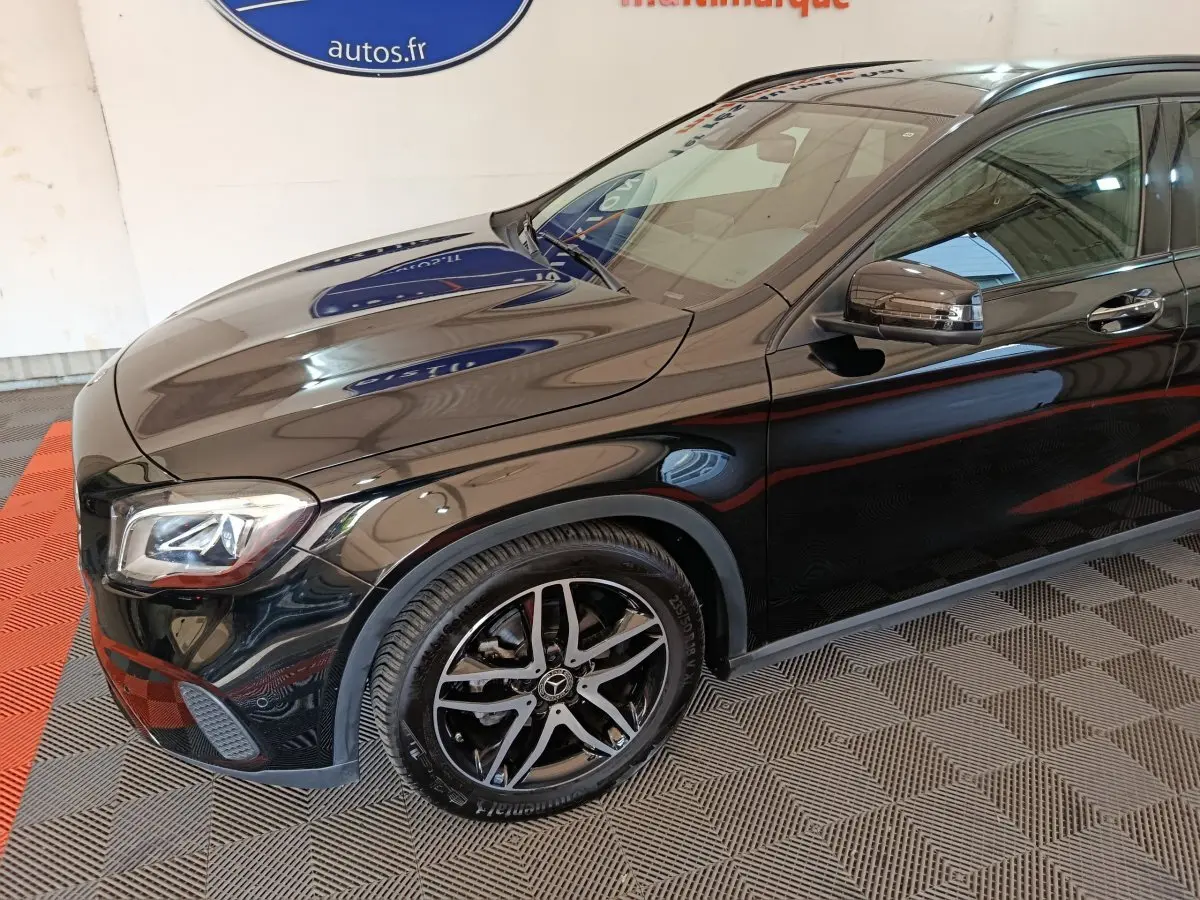 Vue de 3/4 avant droit d'un Mercedes GLA 220 d noir brillant avec jantes alliage et rétroviseurs intégrant clignotants.