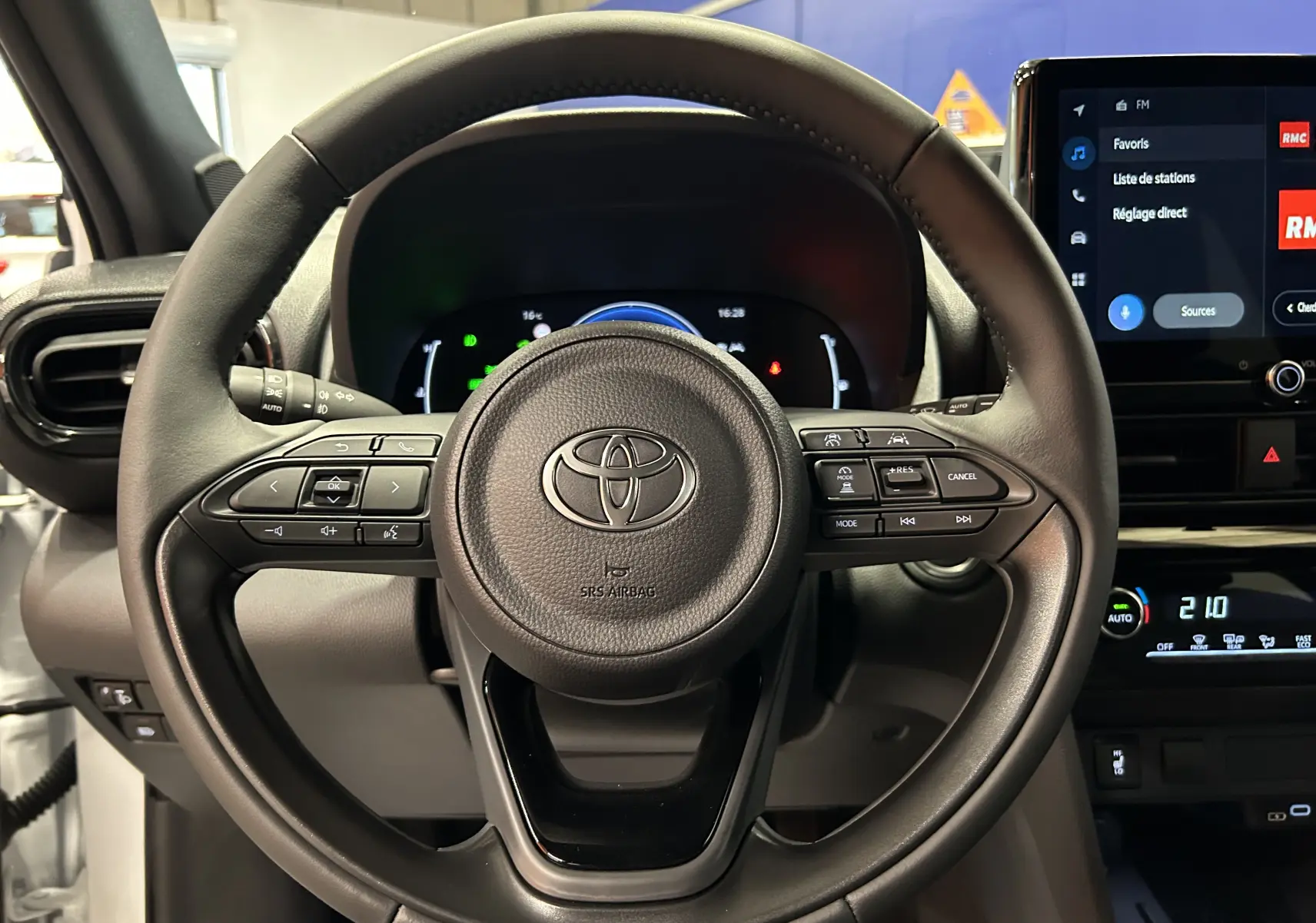 Vue rapprochée du volant multifonction noir de la Toyota Yaris Cross 130 Design 2025 avec tableau de bord digital et écran tactile.