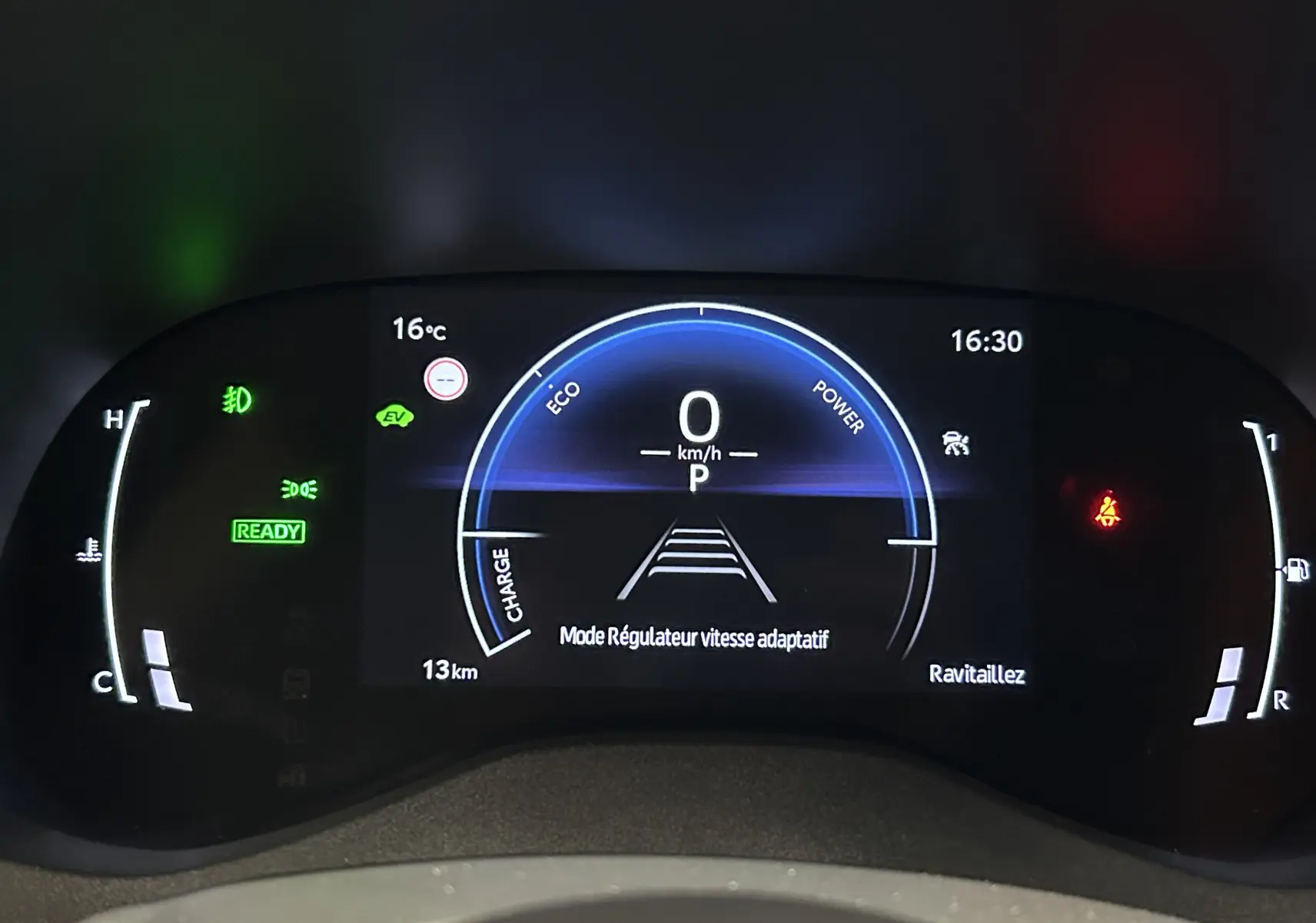 Tableau de bord numérique de Toyota Yaris Cross blanc, affichant le régulateur de vitesse adaptatif à 0 km/h.