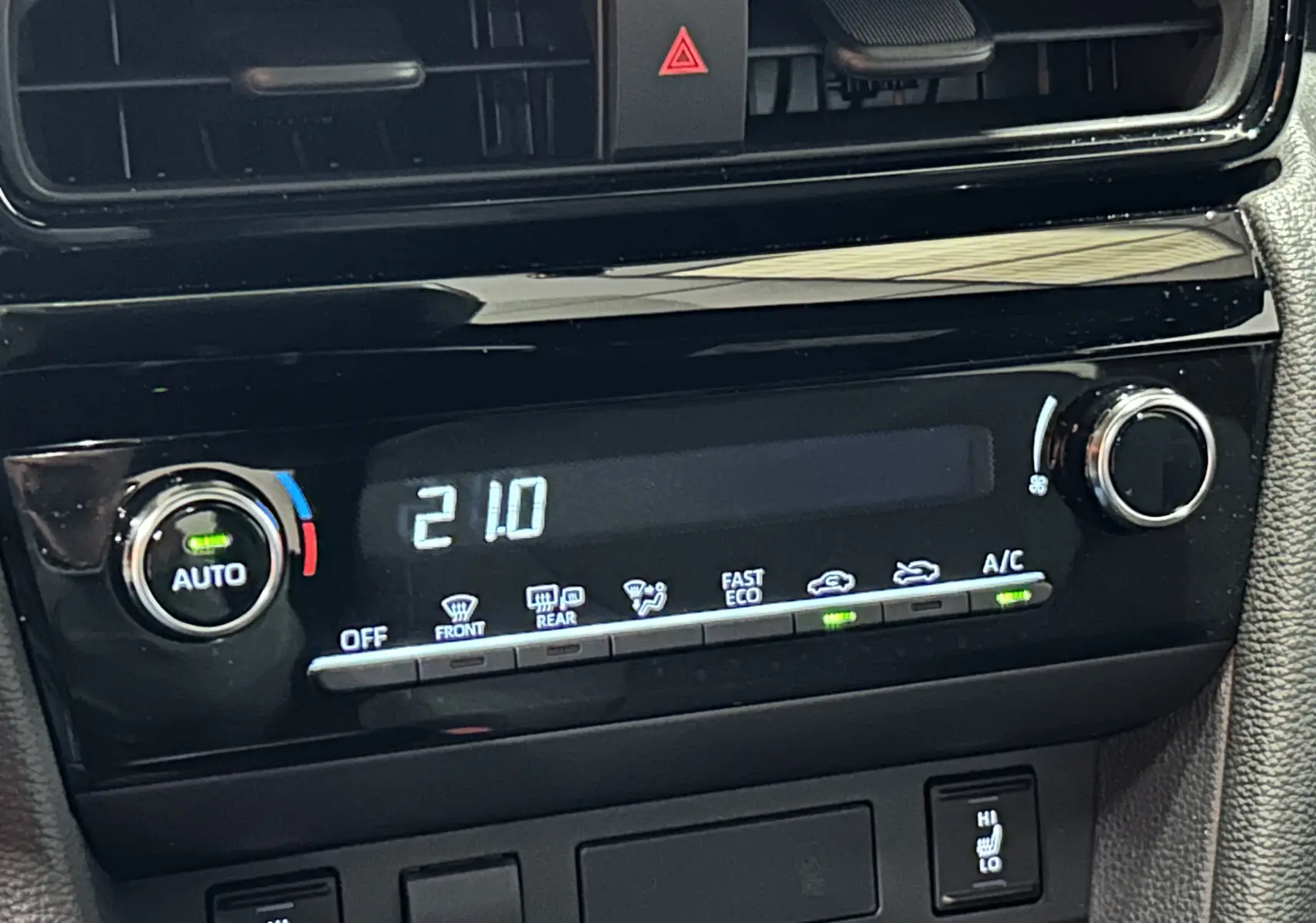 Gros plan sur la commande de climatisation automatique affichant 21°C dans une Toyota Yaris Cross blanche 2025.