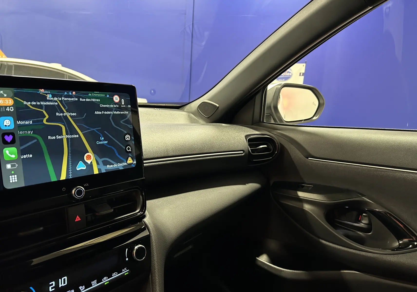 Intérieur de la Toyota Yaris Cross 2025 blanc, vue côté passager avec écran tactile et tableau de bord moderne.