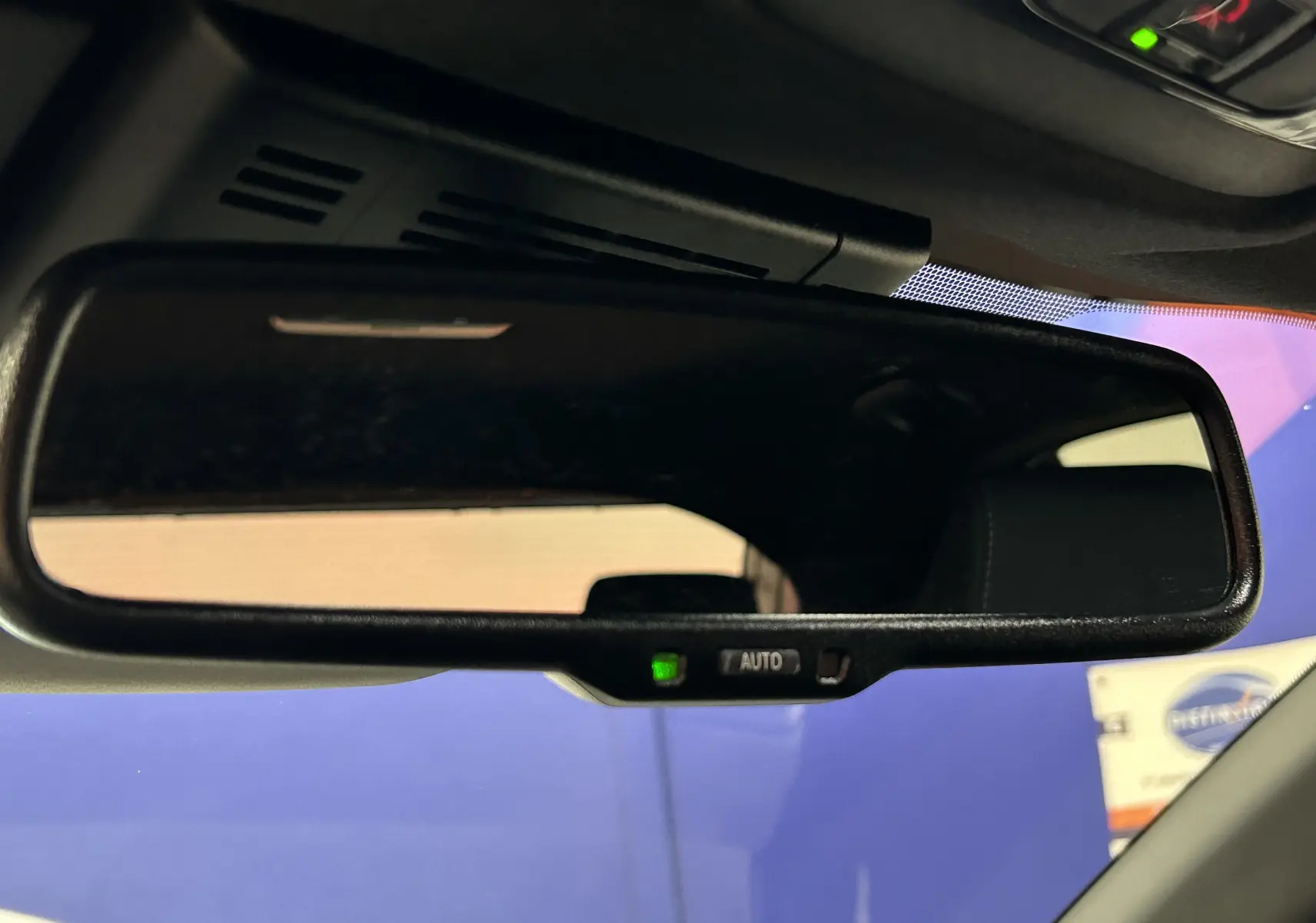 Rétroviseur intérieur automatique avec témoin vert sur Toyota Yaris Cross blanc, vue rapprochée de l'habitacle.