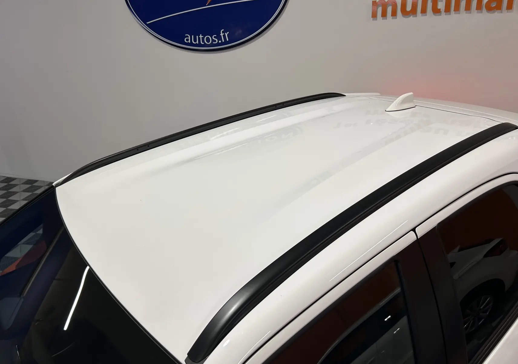 Toit blanc de la Toyota Yaris Cross 2025 avec barres de toit noires et antenne requin en vue plongeante.