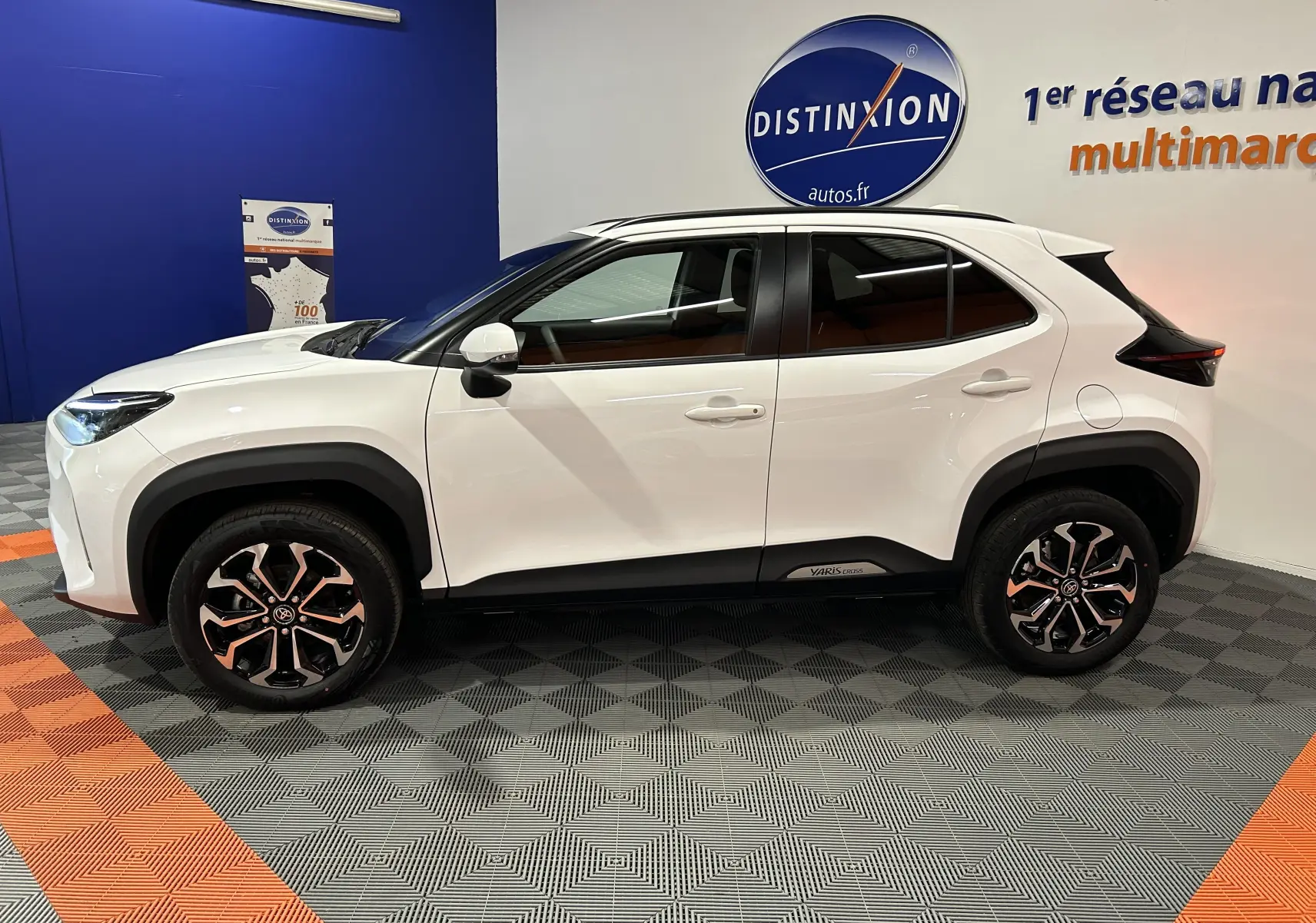 Profil latéral droit d'une Toyota Yaris Cross blanche 2025 avec jantes alliage et détails noirs contrastants.