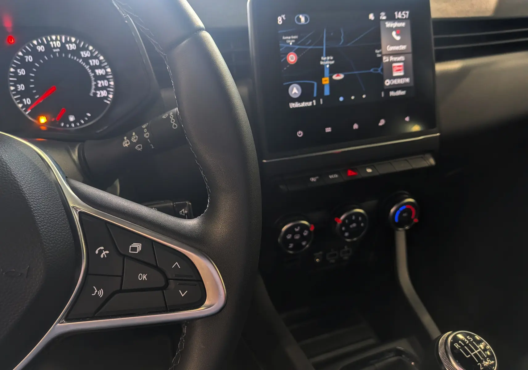 Intérieur de Renault Clio V Blue dCi 100 Business 2021, vue du volant gauche et console centrale avec écran tactile et levier de vitesse manuel.