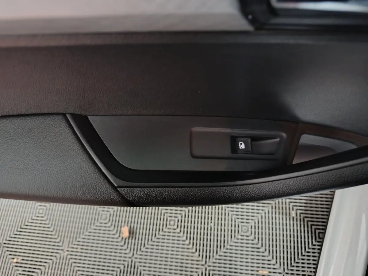 Détail de la poignée intérieure de la porte côté gauche d'un Skoda Karoq 2.0 TDI 2024 avec bouton de verrouillage noir.